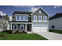 Charming two-story home with green siding, well-manicured lawn, and attached two-car garage at 25 Calabria Ct, Franklinton, NC 27525
