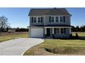 Two-story house with gray siding, a white door, and a curved driveway at 25 Harvest Hills Ln, Dunn, NC 28334