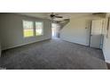Spacious living room with gray carpeting, neutral walls, and two windows at 25 Harvest Hills Ln, Dunn, NC 28334