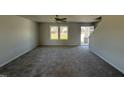 Spacious living room with gray carpeting, neutral walls, and two windows at 25 Harvest Hills Ln, Dunn, NC 28334