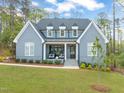 Charming two-story home featuring a well-manicured lawn, neutral paint, black roof, and a welcoming front porch with stylish seating at 2721 Sanctuary Woods Ln, Raleigh, NC 27606