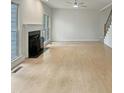 Spacious living room featuring a fireplace, hardwood floors, and large windows at 408 Froyle Ct, Rolesville, NC 27571