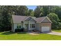 Charming single Gathering home featuring a brick and vinyl exterior, attached two car garage, and well maintained lawn at 46 Trusting Ln, Middlesex, NC 27557