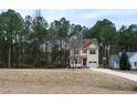 Two-story house with beige siding, red roof accents, and a large yard at 496 Omaha Dr, Broadway, NC 27505