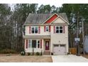 Two-story house with beige siding, red roof accents, and a burgundy front door at 496 Omaha Dr, Broadway, NC 27505
