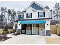 Two-story home with white siding, blue accents, and a modern garage door at 5112 N River Sand Trl, Raleigh, NC 27604