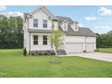 Attractive two-story home featuring a three-car garage and a manicured front yard at 92 Frost Meadow Way, Lillington, NC 27546