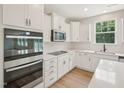Modern kitchen with stainless steel appliances, white cabinets, and quartz countertops at 92 Frost Meadow Way, Lillington, NC 27546