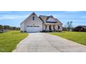 Beautiful home exterior with a two-car garage and a long driveway, set against a green lawn at 1178 Sheriff Johnson Rd, Lillington, NC 27546