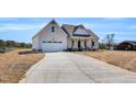 Well-maintained single-story home with a long driveway leading to an attached garage at 1178 Sheriff Johnson Rd, Lillington, NC 27546