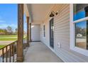 Spacious covered porch featuring wooden columns and a modern outdoor lighting fixture at 1178 Sheriff Johnson Rd, Lillington, NC 27546