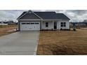 Charming single-Gathering home features a two-car garage, gray accents, and a well-manicured lawn at 135 Jones Creek Ln Ln, Lillington, NC 27546