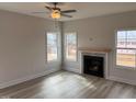 This inviting living room features wood floors, a cozy fireplace, and abundant natural light from large windows at 135 Jones Creek Ln Ln, Lillington, NC 27546