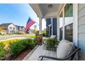 Relaxing front porch view with American flag and glimpse of neighborhood at 166 Retreat Dr, Fuquay Varina, NC 27526