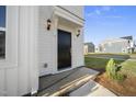A close-up view of a home's black front door with elegant lighting, surrounded by well-maintained landscaping at 51 Pansy Park # 234, Clayton, NC 27520