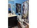 Bathroom with stylish blue walls, a modern vanity, and a decorative shower curtain at 5430 Neuse Ridge Rd, Raleigh, NC 27610