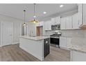 Modern kitchen with white cabinets, granite counters, and stainless steel appliances at 607 Marshskip Way, Rolesville, NC 27571