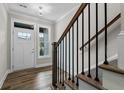 Bright entryway with hardwood floors, white door, and staircase with black railing at 609 Marshskip Way, Rolesville, NC 27571