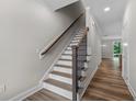 Modern staircase with dark wood railing and white risers at 609 Marshskip Way, Rolesville, NC 27571