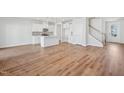 Open-concept living space with hardwood floors, white walls, and staircase with natural light at 907 Montague Ave, Durham, NC 27703