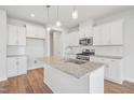 Bright, modern kitchen features an island, stainless steel appliances, and white cabinetry at 911 Montague Ave, Durham, NC 27703