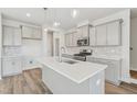 Modern kitchen featuring an island, gray cabinets, stainless steel appliances, and stylish pendant lighting at 913 Montague Ave, Durham, NC 27703