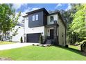 Modern two-story house with white and black exterior, stone accents, and a landscaped yard at 914 Ardmore Dr, Durham, NC 27713