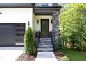 Modern front entrance with stone pillars, wood door, and metal railing at 914 Ardmore Dr, Durham, NC 27713