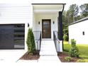 Stylish front entry with a modern wood door and black metal railings at 916 Ardmore Dr, Durham, NC 27713