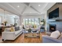 Spacious living room with hardwood floors, fireplace, and large windows offering wooded views at 1 Kelsey Ct, Hillsborough, NC 27278