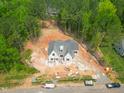 An aerial view shows a new build with brick, surrounded by green forest at 1117 Delilia Ln, Wake Forest, NC 27587