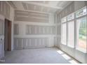 Bright living room with fresh drywall and large windows allowing natural light, ready for customization and personalized touches at 1117 Delilia Ln, Wake Forest, NC 27587