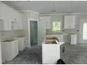 Bright kitchen boasting ample storage, white cabinets, and center island with a view of the yard at 132 Black Cloud Dr, Louisburg, NC 27549