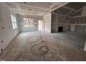 Bright living room featuring large windows, fireplace and unfinished floors at 139 Red River Dr, Selma, NC 27576