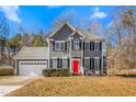 Two-story gray house with a red door, white garage door, and landscaping at 300 Ashwick Dr, Efland, NC 27243