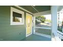 Quaint front porch with white railings and yellow door at 300 Worth St, Raleigh, NC 27601