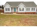 Inviting single-story home with a cozy front porch, a teal front door, and neat landscaping along the foundation at 35 Meadow Ln, Franklinton, NC 27525