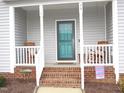 Front porch with rocking chairs and teal front door at 35 Meadow Ln, Franklinton, NC 27525