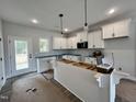 Bright kitchen with white cabinets, a spacious island, and modern black hardware at 404 Brodie Rose Landing Way, Smithfield, NC 27577