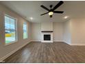 Open-concept living room with modern fireplace and ample natural light from the large windows at 404 Brodie Rose Landing Way, Smithfield, NC 27577
