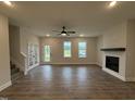 Spacious living room features a modern fireplace, ceiling fan, and windows that bring in plenty of natural light at 404 Brodie Rose Landing Way, Smithfield, NC 27577