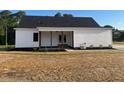 Home featuring a covered porch with wood columns, back yard, and white siding at 541 Delma Grimes Rd, Coats, NC 27521