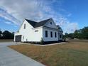 Exterior angle view of home with white siding, concrete driveway, and two-car garage at 541 Delma Grimes Rd, Coats, NC 27521
