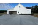 Rear view of home featuring an attached two-car garage and concrete driveway at 541 Delma Grimes Rd, Coats, NC 27521