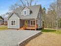 An eye-catching gray house with a charming porch, set in a serene landscape at 624 S Eighth St, Mebane, NC 27302