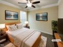 Virtually staged bedroom with a queen bed, two nightstands, and large windows at 7434 Randshire Way, Raleigh, NC 27616