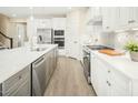 Modern kitchen with stainless steel appliances, white cabinets, and a sleek center island with a sink at 8817 Tartan Clan Dr, Angier, NC 27592