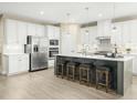 Bright kitchen featuring white cabinets, stainless steel appliances, and a large center island with seating at 8817 Tartan Clan Dr, Angier, NC 27592