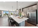 Bright kitchen with an oversized island, modern cabinetry, stainless steel appliances, and pendant lighting at 107 Ailey Brook Way # 200, Wake Forest, NC 27587