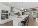 Bright, open kitchen with a large island, stainless steel appliances, and modern white cabinetry with bar stool seating at 109 Ailey Brook Way # 200, Wake Forest, NC 27587